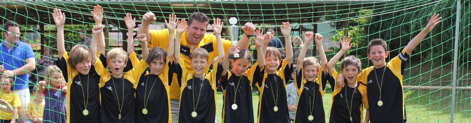 Spieler und Trainer unserer Fussball-Jugendmannschaft freuen sich auf Grund des gewonnenen Pokals beim Willi-Mark-Turnier.